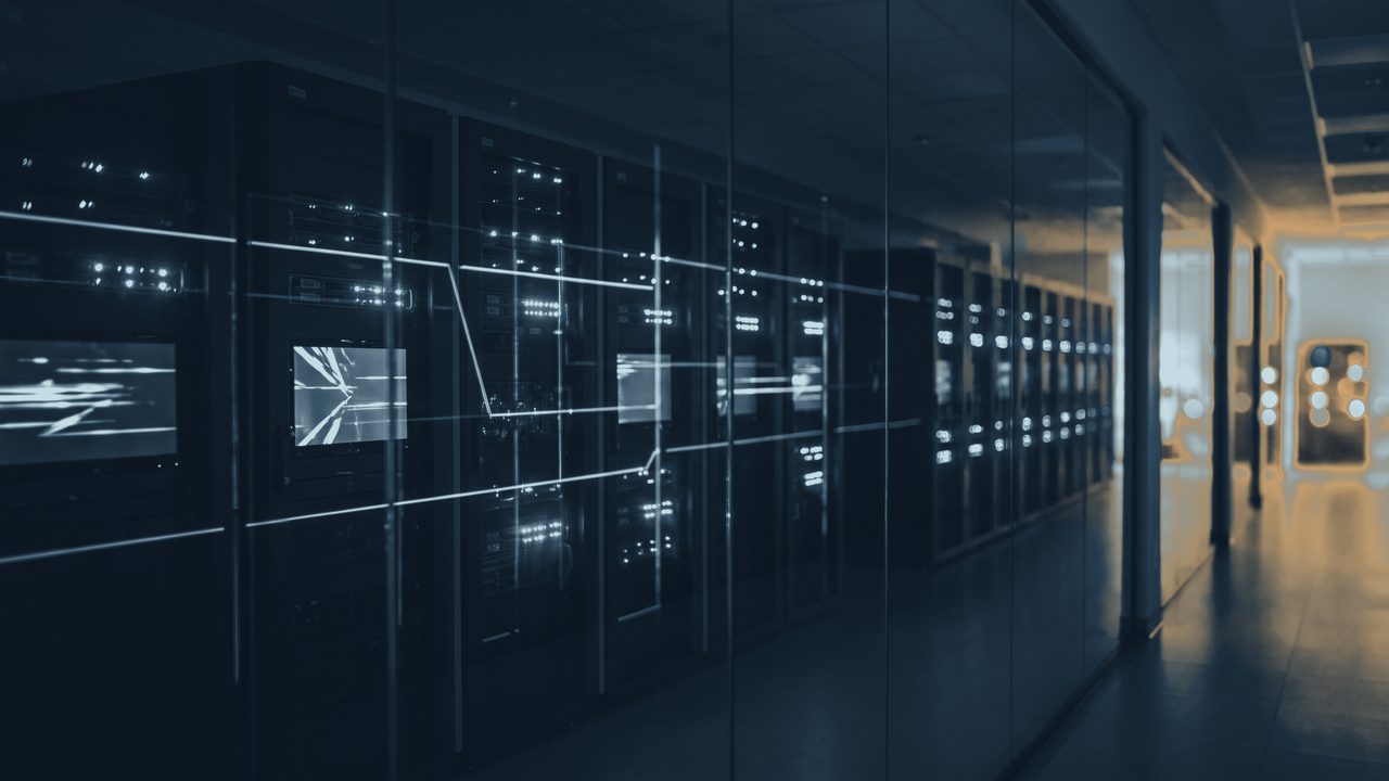 A row of server cabinets in a data hall, lit by the indicators on their front panels.